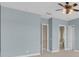 Bright bedroom featuring blue walls, a ceiling fan, and access to a bathroom and closet at 2255 Stone Lake Ct, Orlando, FL 32824