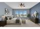Main bedroom with plush bedding, modern décor, and triple windows overlooking the neighborhood at 2255 Stone Lake Ct, Orlando, FL 32824
