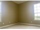 Empty room features neutral paint, carpet, base molding, and large windows at 2255 Stone Lake Ct, Orlando, FL 32824