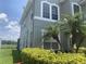 Two-story house with view of the lake behind the palm trees and manicured green shrubs at 2255 Stone Lake Ct, Orlando, FL 32824