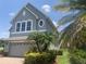 Two-story home with large arched windows, an oval window and landscaped with palm trees and manicured green shrubs at 2255 Stone Lake Ct, Orlando, FL 32824