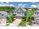 Aerial view of a two-story home with lush landscaping and a brick driveway near a pond at 2255 Stone Lake Ct, Orlando, FL 32824