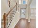 Bright foyer with hardwood floors, a staircase with white railings, and a decorative glass front door at 2255 Stone Lake Ct, Orlando, FL 32824