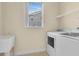 Laundry room with washer, dryer, utility sink, shelving, and window at 2255 Stone Lake Ct, Orlando, FL 32824