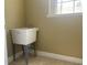 Utility sink in laundry room with tiled flooring, and a bright window above at 2255 Stone Lake Ct, Orlando, FL 32824
