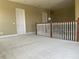 Large, carpeted loft space with wooden railing and a view of the home's interior doors and fixtures at 2255 Stone Lake Ct, Orlando, FL 32824
