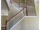 A staircase features a classic design with white balusters and wood railing, creating an elegant transition between floors at 2255 Stone Lake Ct, Orlando, FL 32824