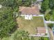 Aerial view of the property showcasing a large backyard, patio, shed, and surrounding mature trees at 2493 Pine Chase Cir, St Cloud, FL 34769