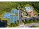 Overhead view of community amenities including tennis courts, a pool, clubhouse, and a parking area at 2736 Atherton Dr, Orlando, FL 32824