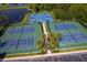 Overhead view of basketball and tennis courts surrounded by lush trees, offering a recreational lifestyle at 2736 Atherton Dr, Orlando, FL 32824