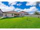 Green backyard view showing the back of the house, patio, and a lush lawn to the fence line at 2736 Atherton Dr, Orlando, FL 32824