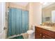 Bright bathroom with granite countertop, shower with patterned blue curtain, and neutral wall paint at 2736 Atherton Dr, Orlando, FL 32824
