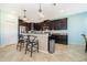 A kitchen featuring dark cabinets, granite countertops, stainless steel appliances, and pendant lighting over a breakfast bar at 2736 Atherton Dr, Orlando, FL 32824