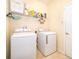Bright laundry room featuring washer, dryer, shelving, and tile flooring at 2736 Atherton Dr, Orlando, FL 32824