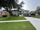 Two-story home boasts green lawn, a driveway, and a two-car garage, enhanced by stone accents and lush landscaping at 2750 Eagle Lake Dr, Clermont, FL 34711