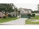 Two-story home with a green lawn, a driveway and a two-car garage, featuring stone accents and meticulous landscaping at 2750 Eagle Lake Dr, Clermont, FL 34711