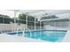 Inviting in-ground pool featuring a white enclosure, diving board, and ladder for easy access at 2750 Eagle Lake Dr, Clermont, FL 34711