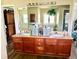 Bathroom featuring double sinks, wood cabinetry, and a large mirror at 3 Sunrise Dr, Ocala, FL 34472