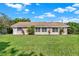 This backyard features a lush lawn and complements the home's neutral exterior with multiple windows at 3 Trophy Ln, Kissimmee, FL 34759