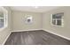 Bright bedroom featuring gray wood flooring and multiple windows providing natural light at 3 Trophy Ln, Kissimmee, FL 34759