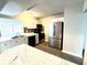 Well-lit kitchen featuring stainless steel appliances, white cabinets, and updated countertops at 3 Trophy Ln, Kissimmee, FL 34759