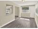 Sunlit room with gray wood floors, connecting living spaces, and neutral wall paint at 3 Trophy Ln, Kissimmee, FL 34759