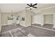 Open-concept living area with gray wood floors, neutral paint, and a view into the kitchen at 3 Trophy Ln, Kissimmee, FL 34759