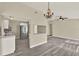 Spacious open-concept with a kitchen bar, chandelier, ceiling fan, and modern gray wood floors at 3 Trophy Ln, Kissimmee, FL 34759
