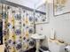 Bathroom features a pedestal sink, patterned shower curtain, and a mirrored medicine cabinet at 301 Oregon Ave, St Cloud, FL 34769