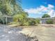 Well-kept house exterior features a long driveway and partially xeriscaped front yard with mature trees at 301 Oregon Ave, St Cloud, FL 34769