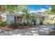 Charming, painted brick home with a well-manicured, partially shaded front yard with palm trees at 301 Oregon Ave, St Cloud, FL 34769