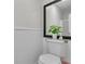 White half bathroom features a decorative mirror, plant, and a toilet at 3173 Wake Up Ct, Kissimmee, FL 34744