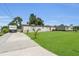 Charming single-story home with well-maintained lawn and long driveway on a sunny day at 3173 Wake Up Ct, Kissimmee, FL 34744