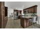 Open kitchen with granite countertops, stainless appliances, dark cabinets, and breakfast bar at 3173 Wake Up Ct, Kissimmee, FL 34744