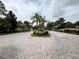 Community entrance featuring a palm tree lined roundabout with lush landscaping at 3664 Wilshire Way Rd # 261, Orlando, FL 32829