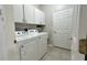 Bright laundry room features cabinetry above a front-load washer and dryer at 3901 Ballinore Pl, Gotha, FL 34734
