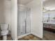 The bathroom features a clear glass shower, toilet, and tile flooring with doorway to a bedroom at 3991 Island Lakes Dr, Winter Haven, FL 33881