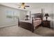 Serene primary bedroom featuring a four-poster bed, ceiling fan, and a large window for natural light at 3991 Island Lakes Dr, Winter Haven, FL 33881