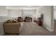 This living room features a beige sofa with pillows, wooden desk, media center and neutral carpet at 3991 Island Lakes Dr, Winter Haven, FL 33881