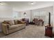This living room features a beige sofa with pillows, wooden desk, media center and neutral carpet at 3991 Island Lakes Dr, Winter Haven, FL 33881