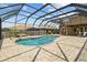Stunning screened-in pool area features a waterfall, stone pavers, and plenty of space for outdoor entertaining at 3991 Island Lakes Dr, Winter Haven, FL 33881