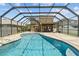 The screened-in pool features a stone waterfall feature, and outdoor dining and lounging areas at 3991 Island Lakes Dr, Winter Haven, FL 33881