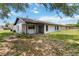 Exterior of house with covered back porch and large grassy yard at 406 Long Dr, Kissimmee, FL 34759