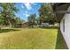 Large grassy backyard with mature trees and a chain-link fence at 406 Long Dr, Kissimmee, FL 34759