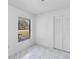 Bright bedroom features marble-look tile floor, closet, and a sunlit window at 406 Long Dr, Kissimmee, FL 34759