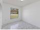 Bedroom features marble-look tile floors, a window, and a closet at 406 Long Dr, Kissimmee, FL 34759