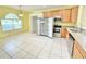 Bright kitchen featuring wooden cabinetry, stainless steel appliances, and a tile floor at 4307 Creeks Run Blvd, Kissimmee, FL 34746