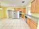 Bright kitchen featuring wooden cabinetry, stainless steel appliances, and a tile floor at 4307 Creeks Run Blvd, Kissimmee, FL 34746