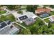An aerial view of a home features a screened-in pool, a lanai, solar panels, and verdant landscaping at 4407 Lake Trudy Dr, St Cloud, FL 34769
