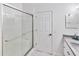 Modern bathroom with a glass shower, gray vanity, and white walls at 4407 Lake Trudy Dr, St Cloud, FL 34769